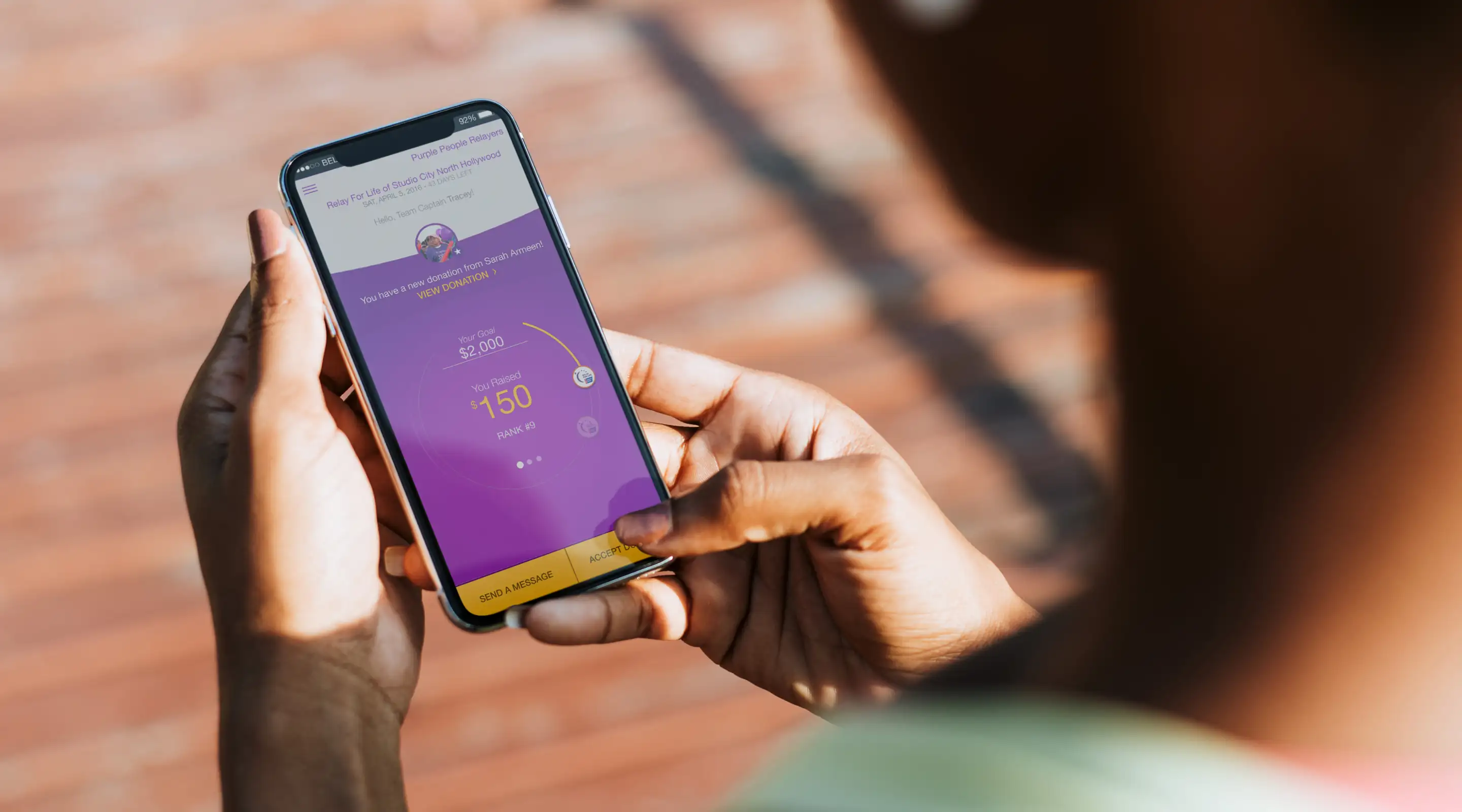 Closeup shot of person using their mobile device with the American Cancer Society FUNdraising app on screen